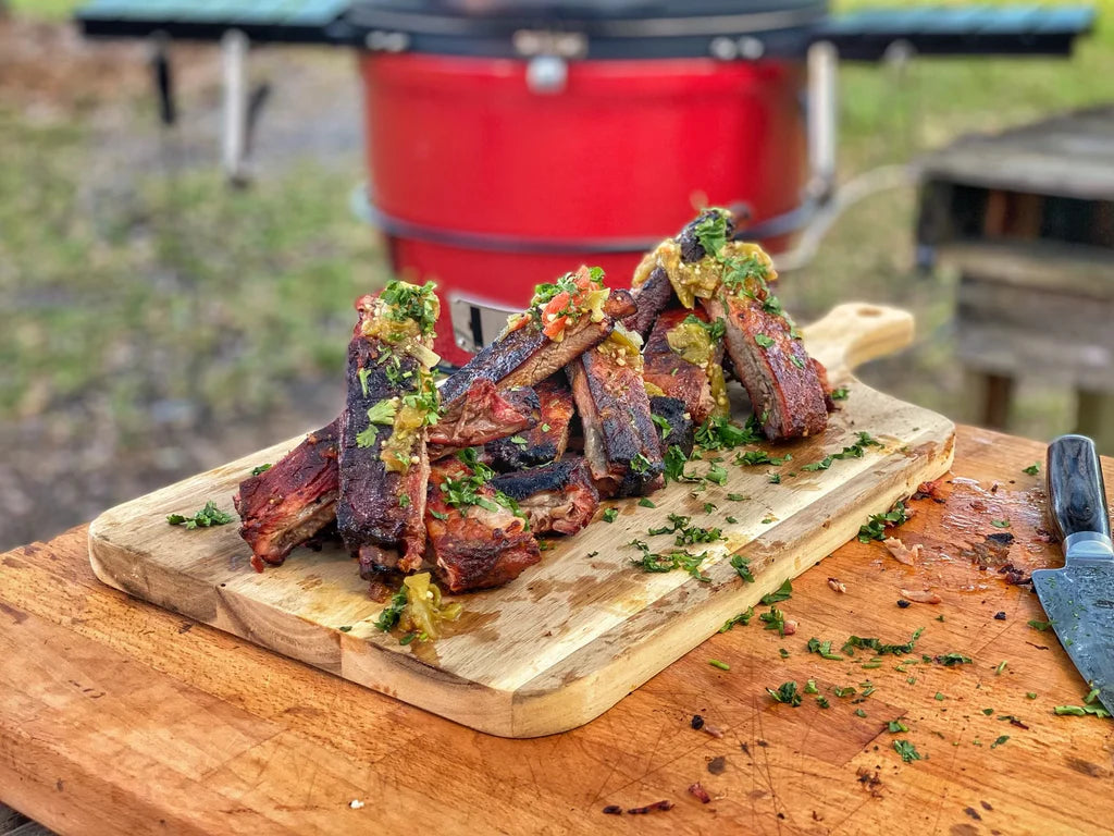 A pile of Green Chile and Chipotle Ribs cut apart and resting on a wooden board, ready for serving